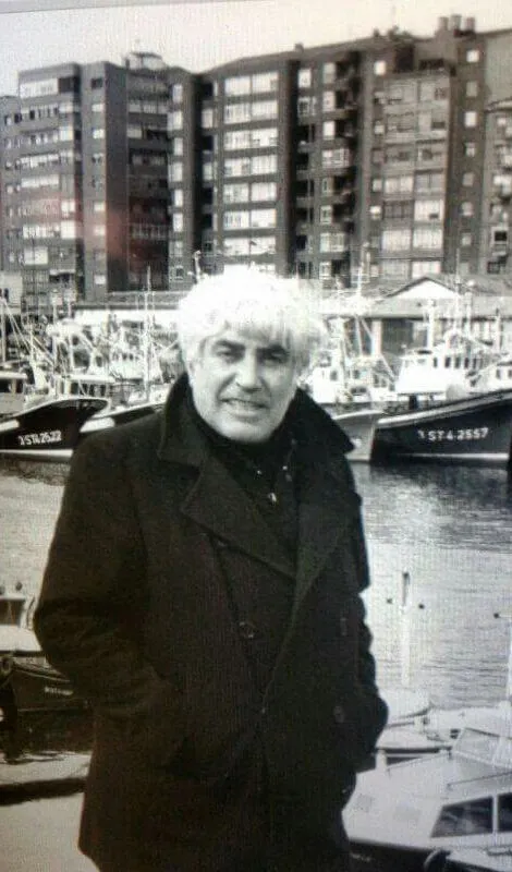 Don Alberto Pico junto a la dársena, con barcos y bodegas del barrio al fondo