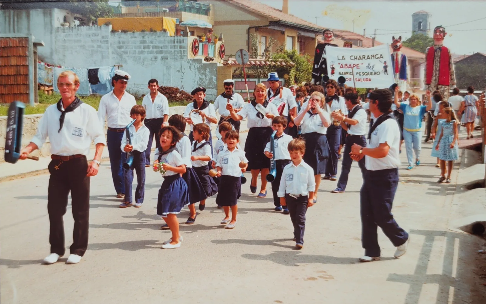 La charanga del Barrio Pesquero desfilando por las calles de San Román de la Llanilla, con los niños del barrio delante