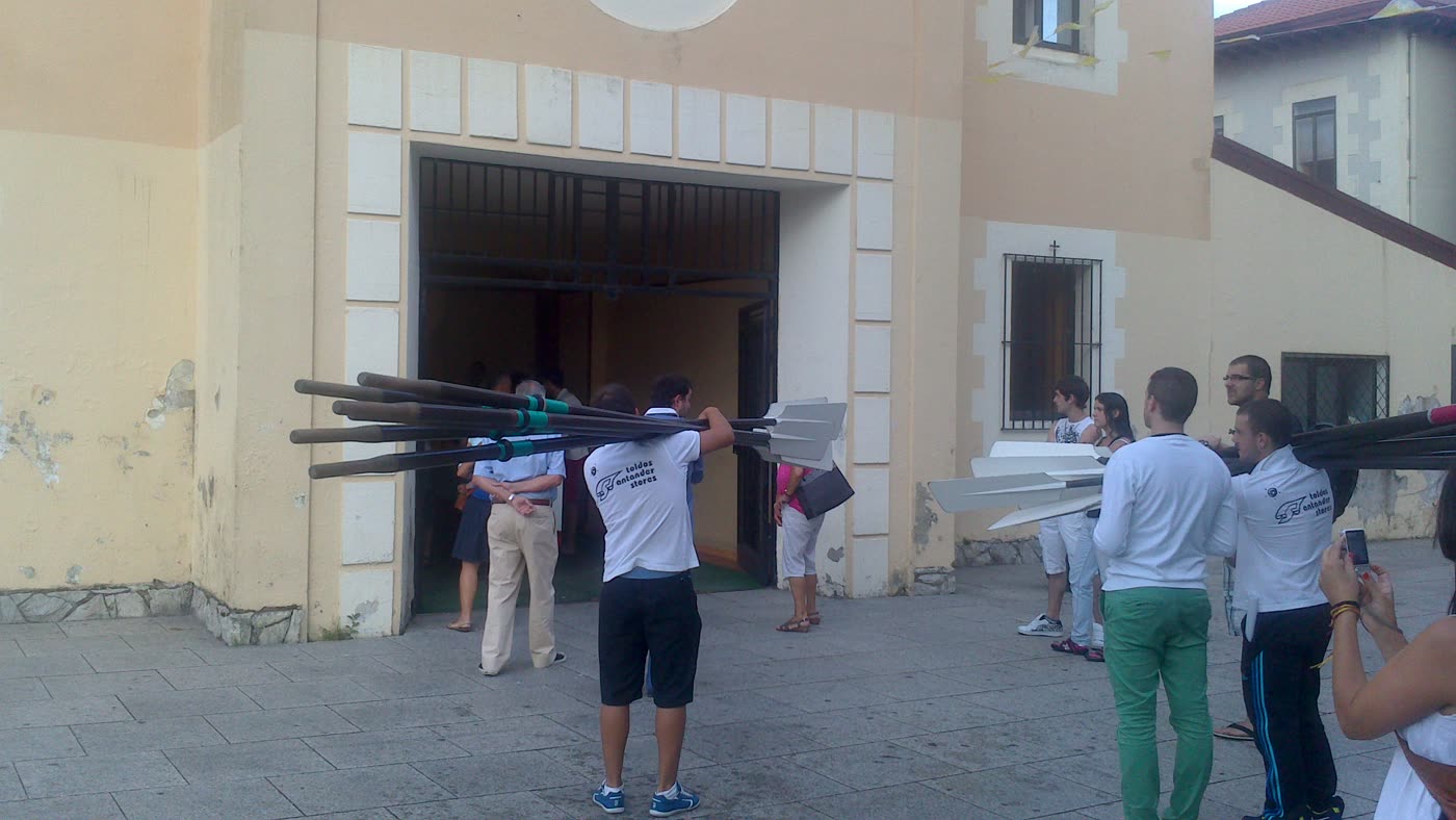 Remeros entrando en la iglesia con los remos al hombro